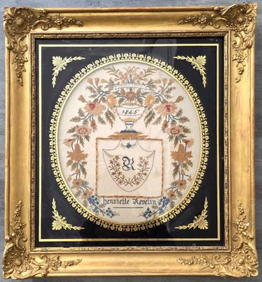 un tableau dans un cadre ouvragé représentant un blason sur lequel figure un blason