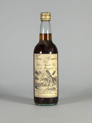 une bouteille de rhum posée sur une table, sur fond gris