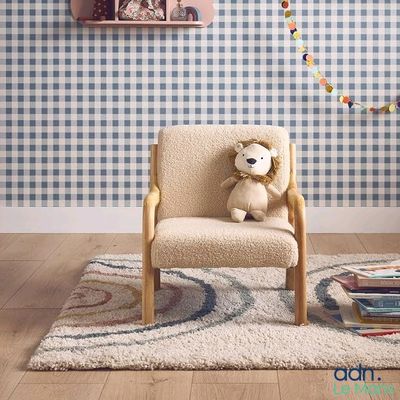 un ours en peluche assis sur une chaise dans une pièce