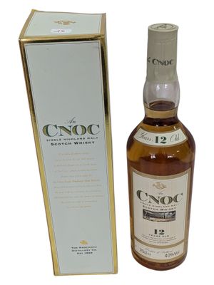 a bottle of whisky in front of a box on a white background
