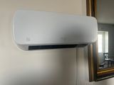 un climatiseur blanc accroché au mur à côté d'un miroir