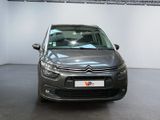 grey citrole car parked in a showroom with a sign on the wall