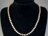 un collier de perles blanches sur un mannequin noir