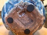 a close up of a blue and brown vase on a table