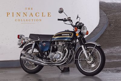 a motorcycle that is parked in front of the pinnacle collection sign
