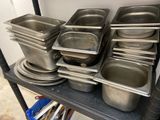 de nombreuses casseroles et poêles rangées sur une étagère dans la cuisine