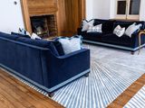 a living room with blue couches and a fireplace in the corner