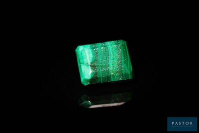 un gros plan d'une émeraude verte sur une surface noire
