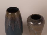 two vases sitting next to each other on a table