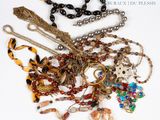 de nombreux colliers et bracelets posés sur un fond blanc