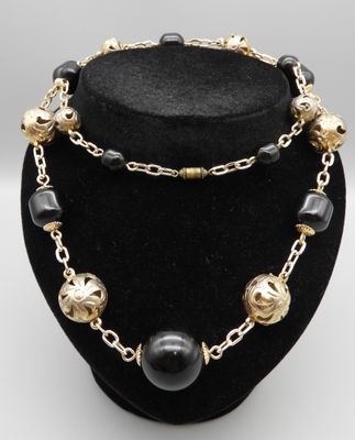 Collier en perles de métal doré et résine noire.