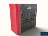 une image représentant un livre à la couverture rouge posé sur une surface blanche