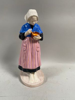 une figurine représentant une femme tenant une assiette de nourriture