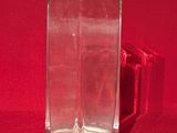 un vase en verre posé sur un tissu rouge