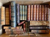 de nombreux livres anciens dans une boîte posée sur une étagère