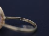 close up of a diamond ring on a table with a black background