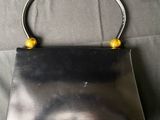 an image of a black purse on a bed
