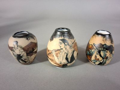 trois vases ornés de motifs différents, posés sur une table