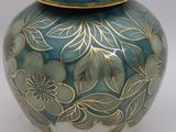 a blue and gold vase with a lid sitting on a table