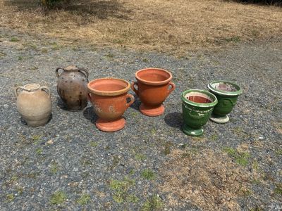 four different pots sitting on the ground next to each other