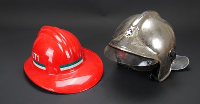 deux casques de pompier posés l'un à côté de l'autre sur une table