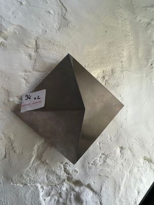 a metal object on the wall with a tag attached to it