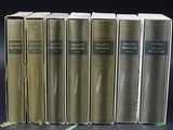 six books are lined up in a row on a black surface