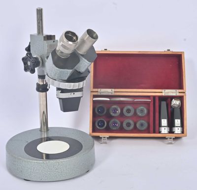 un microscope posé à côté d'une boîte à outils