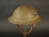 an old military helmet on a stand against a black background