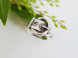 a close up of a silver ring with a face on it