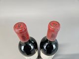 two bottles of wine sitting next to each other on a table