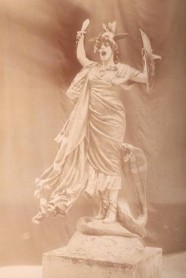une statue de femme tenant un oiseau dans sa main