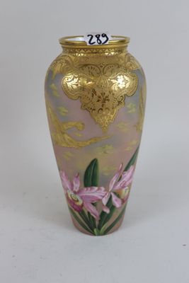 a gold vase with a pink flower painted on it