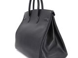 a black leather handbag on a white background