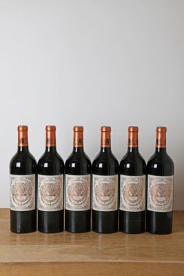 six bouteilles de vin rouge alignées sur une table en bois