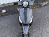 un scooter noir garé devant un immeuble