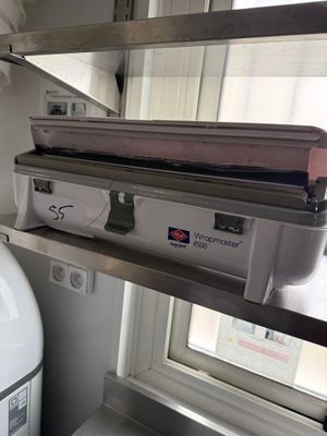 un réfrigérateur blanc sur lequel est posée une boîte rose