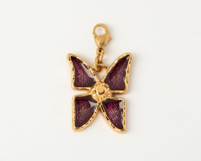 a close up of a butterfly pendant on a white surface
