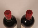 two bottles of wine sitting next to each other on a table