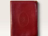 a red leather passport case sitting on top of a white surface