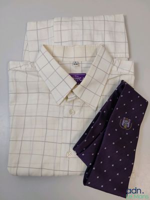 une chemise blanche et une cravate violette posées sur une table