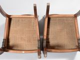 pair of antique wooden chairs with canes on them against a white background