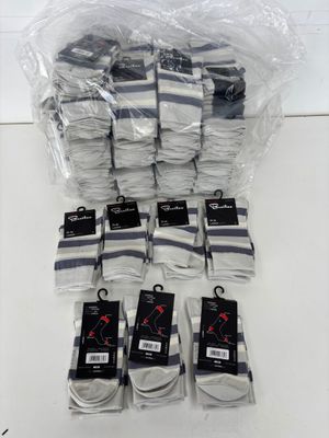 several pairs of white socks are wrapped in plastic bags on a table