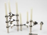 silver metal candle holders with white candles on a white background