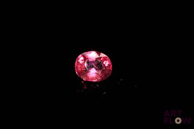 gros plan d'un diamant rose sur une surface noire