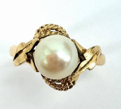 an image of a gold ring with a pearl in the center
