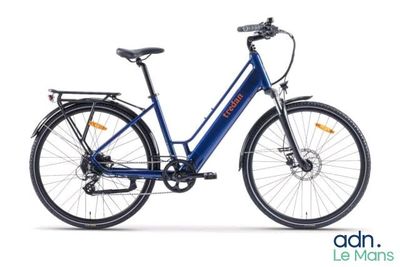 Le vélo électrique bleu est garé sur une surface blanche.