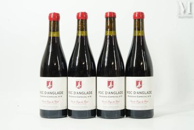 quatre bouteilles de vin rouge posées sur une table blanche