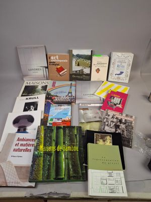 une table sur laquelle se trouvent de nombreux livres et une lampe