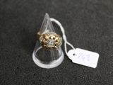 une bague en or ornée d'un crâne sur un fond noir
